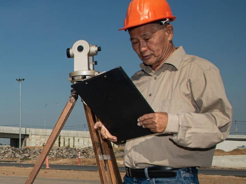 Experienced licensed land surveyor reviewing field notes while conducting a property survey.