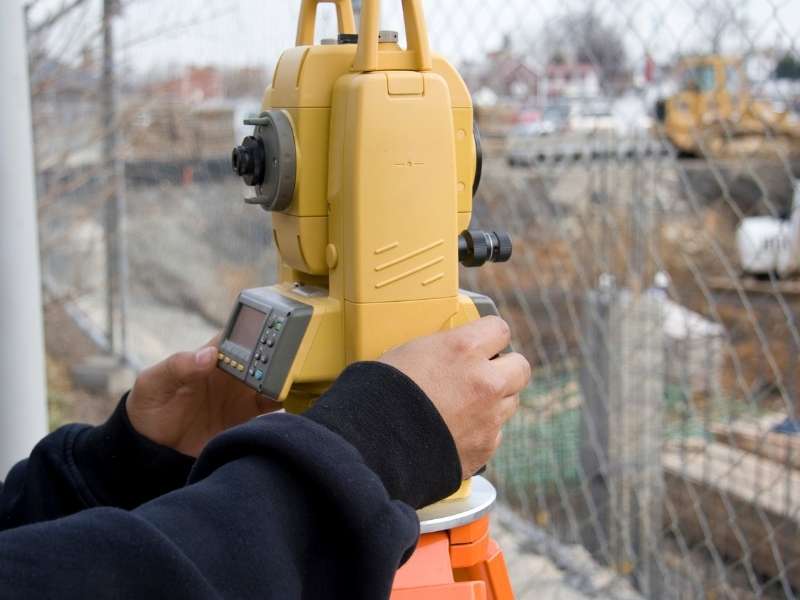 Surveyor for fence placement using professional surveying equipment in Boston, Massachusetts.

